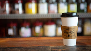 Hot Coffee on bar with hot sleeve